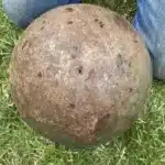 Esfera de acero en arroyo: misterio líquido negro